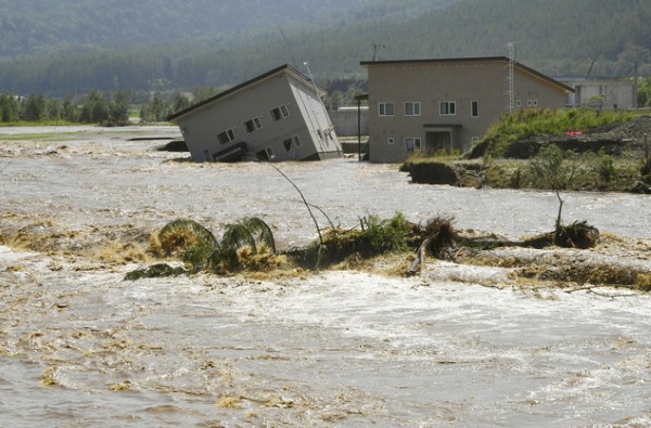 Floodwaters from the Sorachi river wash away a building after embankments of the river were broken in Minami-furano, the northern island of Hokkaido, Japan, Wednesday, Aug. 31, 2016. At least two rivers swollen by Typhoon Lionrock broke through embankments, flooding the areas. (Daisuke Suzuki/Kyodo News via AP)